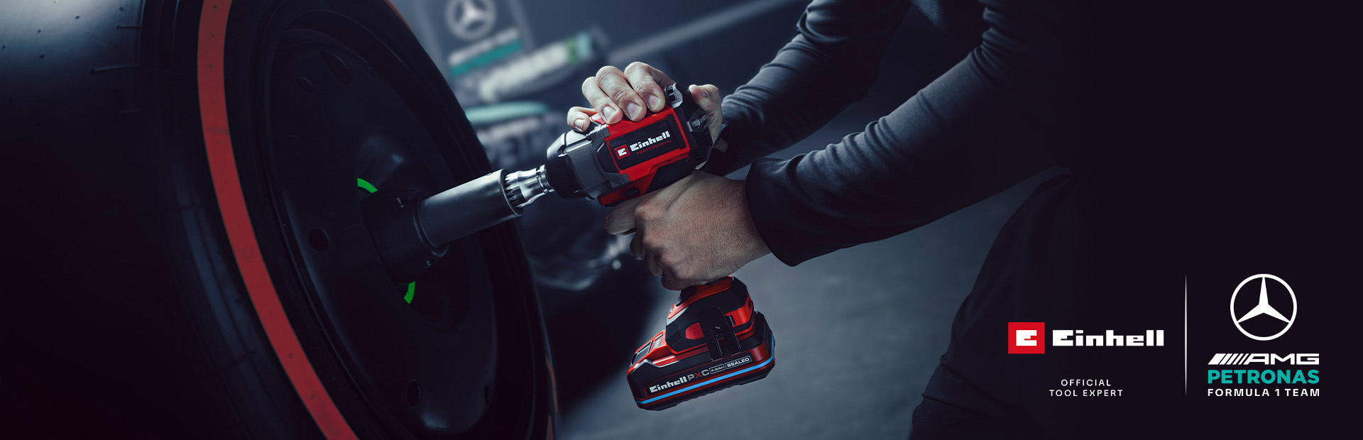 Llave de impacto inalámbrica Einhell en uso sobre una rueda de coche, con el branding y el logotipo de colaboración del equipo Mercedes-AMG Petronas de Fórmula 1