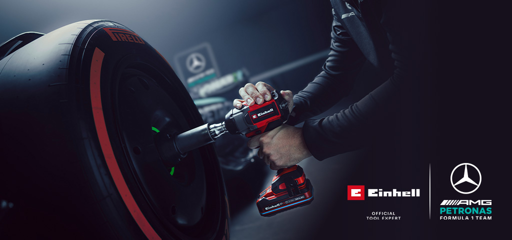 Llave de impacto inalámbrica Einhell en uso sobre una rueda de coche, con el branding y el logotipo de colaboración del equipo Mercedes-AMG Petronas de Fórmula 1