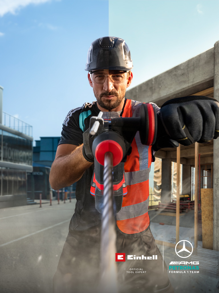 Un mecánico, equipado con ropa de protección, taladrando con una herramienta eléctrica en una obra.